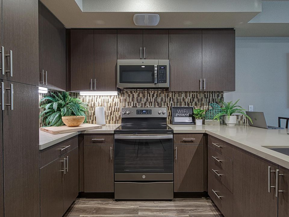Cozy kitchen with dark cabinetry, tile backsplash, and an organized layout suited for everyday cooking.